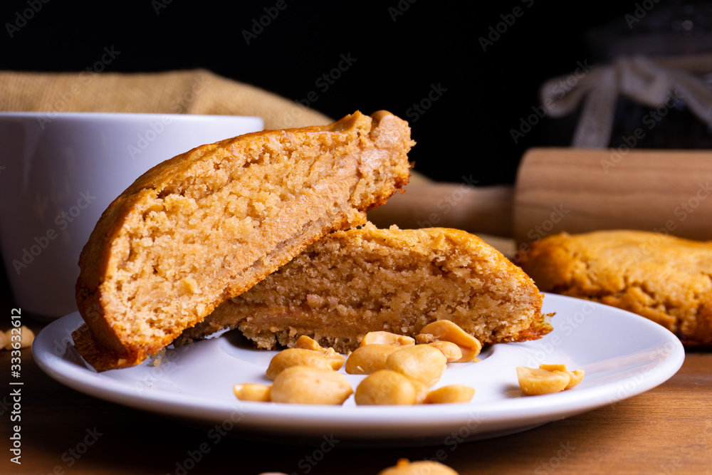 Fresh vegan cookie cakes with peanut butter, peanuts and a cup of coffee on a wooden board with copy