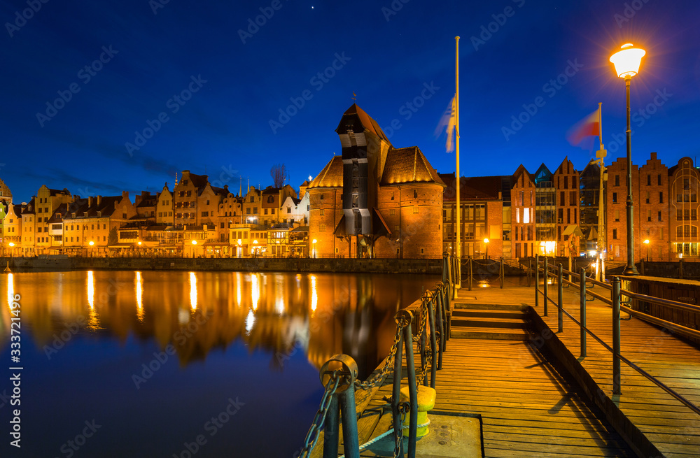 Old town in Gdansk with historical port crane over Motlawa river at night, Poland.