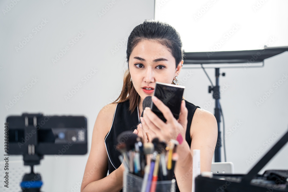 Asian young beauty cosmetic blogger woman use tablet for prepare information before record clip vide