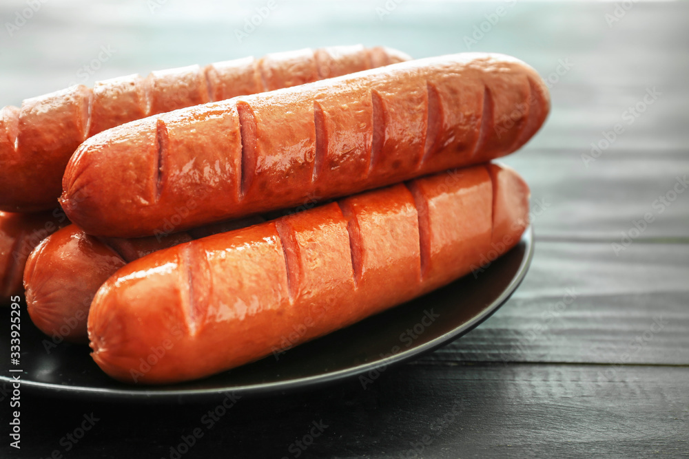 Plate with tasty grilled sausages on table