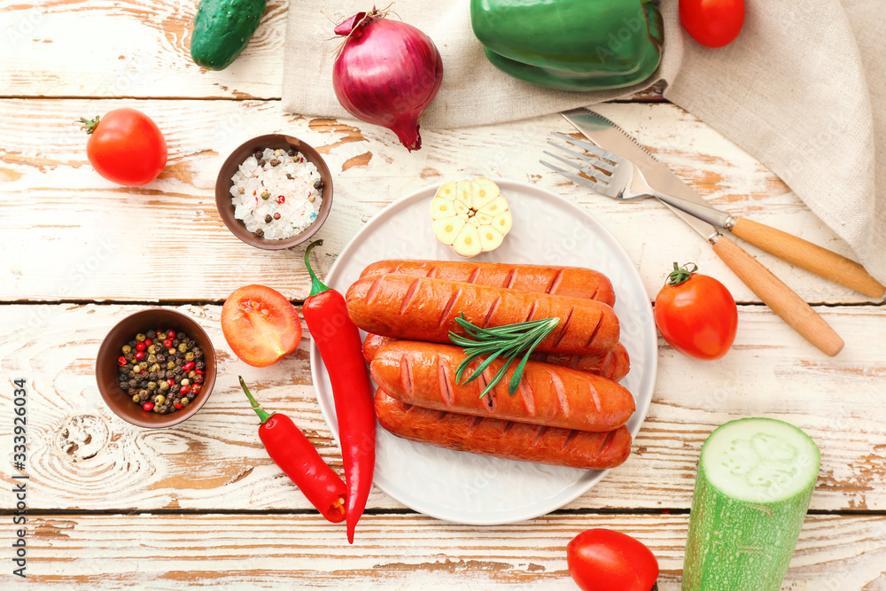 Plate with tasty grilled sausages and vegetables on table