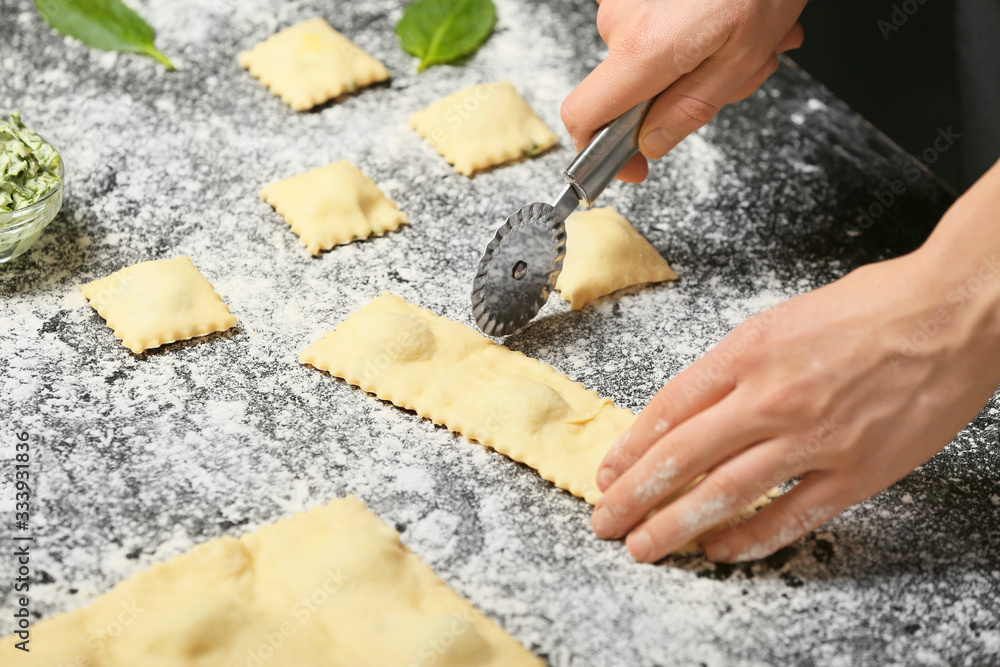 Woman preparing tasty ravioli on table