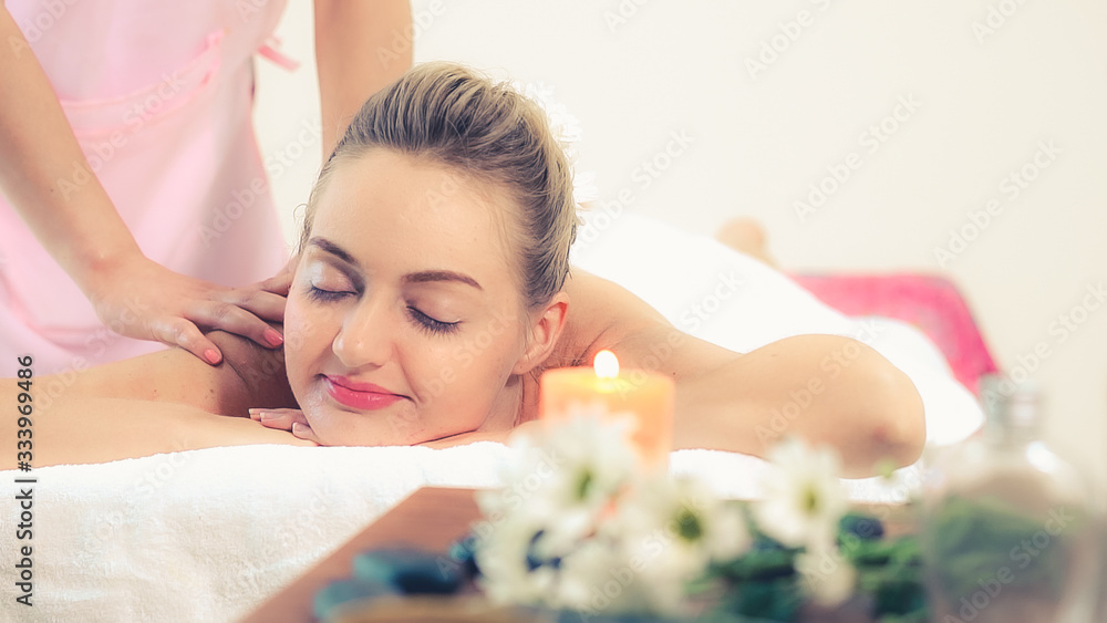 Relaxed woman getting back massage in luxury spa with professional massage therapist. Wellness, heal