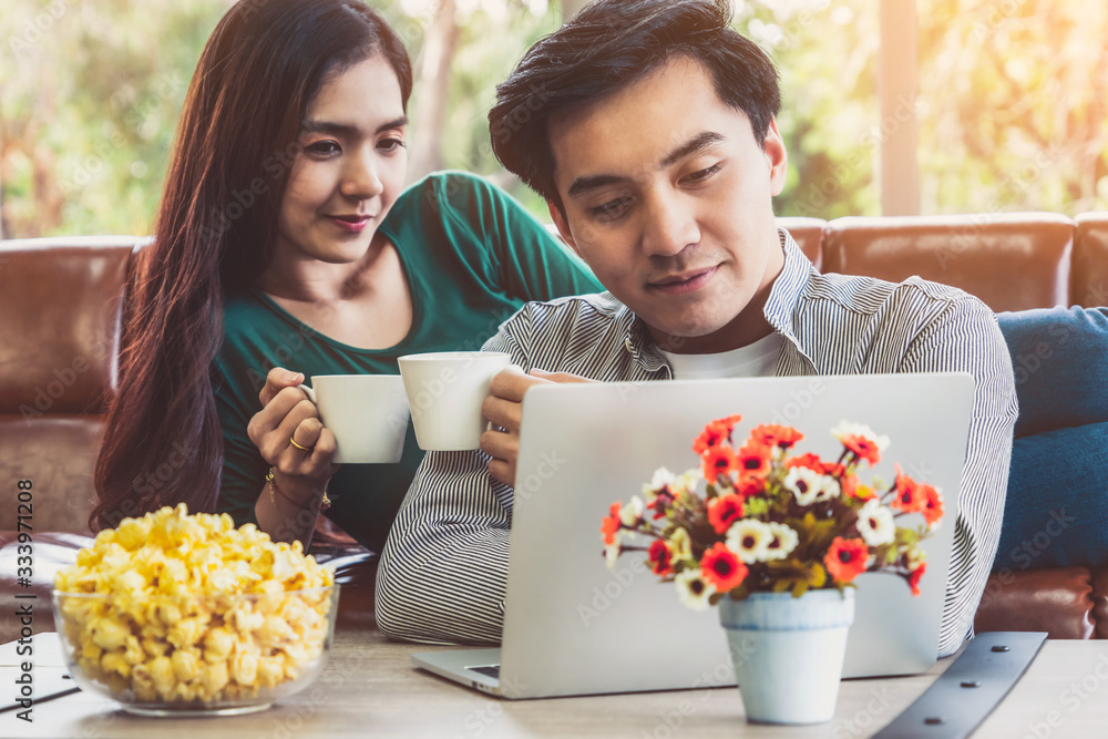 Happy Asian couple drink coffee at home. Love relationship and lifestyle concept.