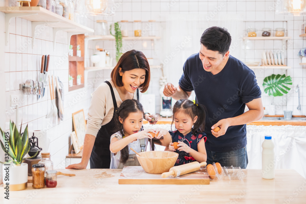 Asian family enjoy playing and cooking food in kitchen at home