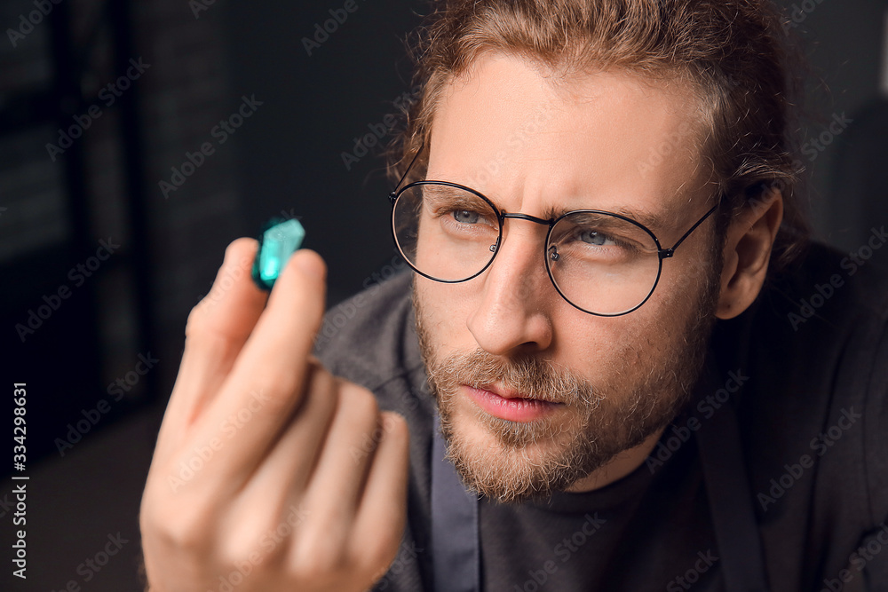 Jeweler examining gemstone in workshop