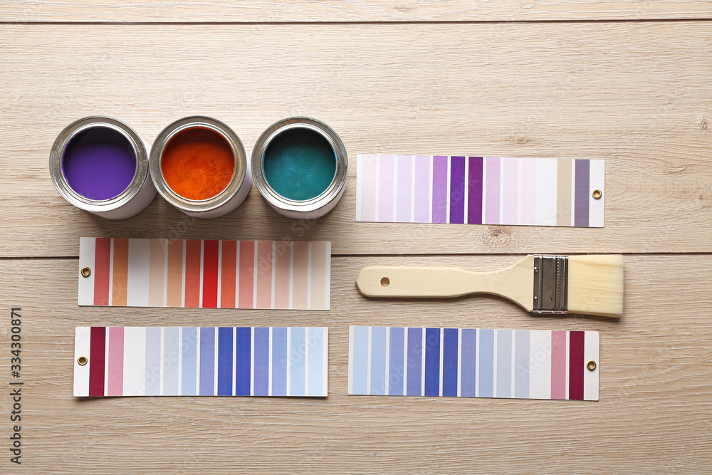 Color swatches with paints and brush on wooden table