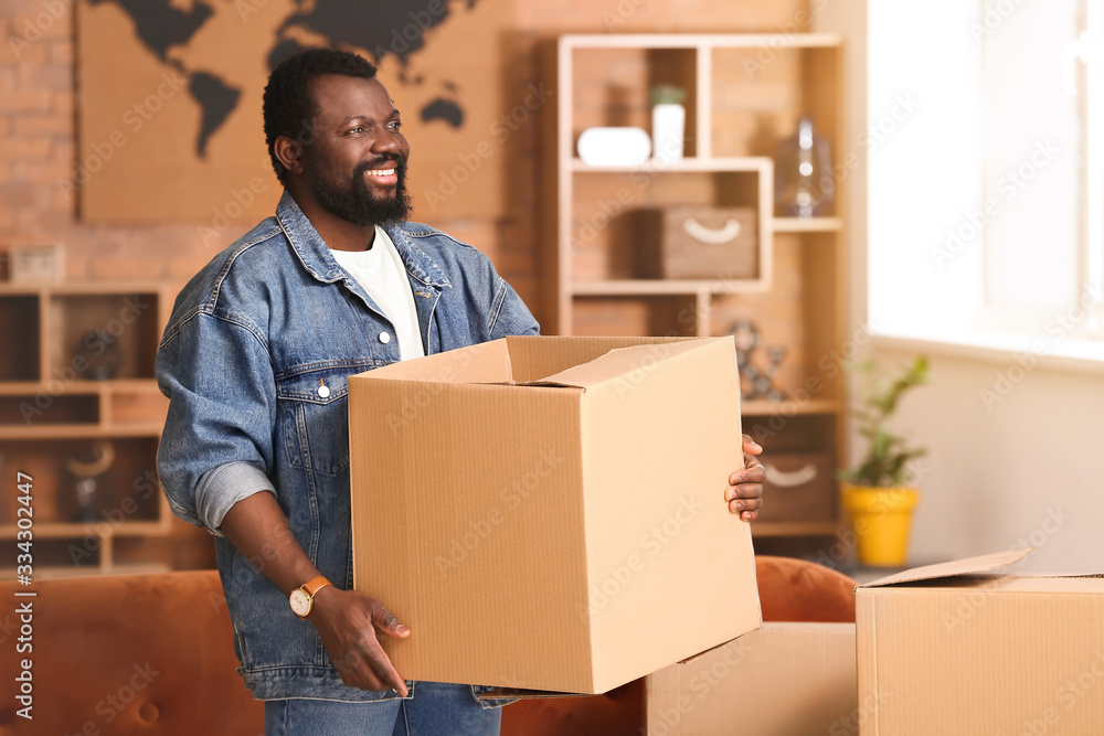 African-American man with moving boxes in his new home