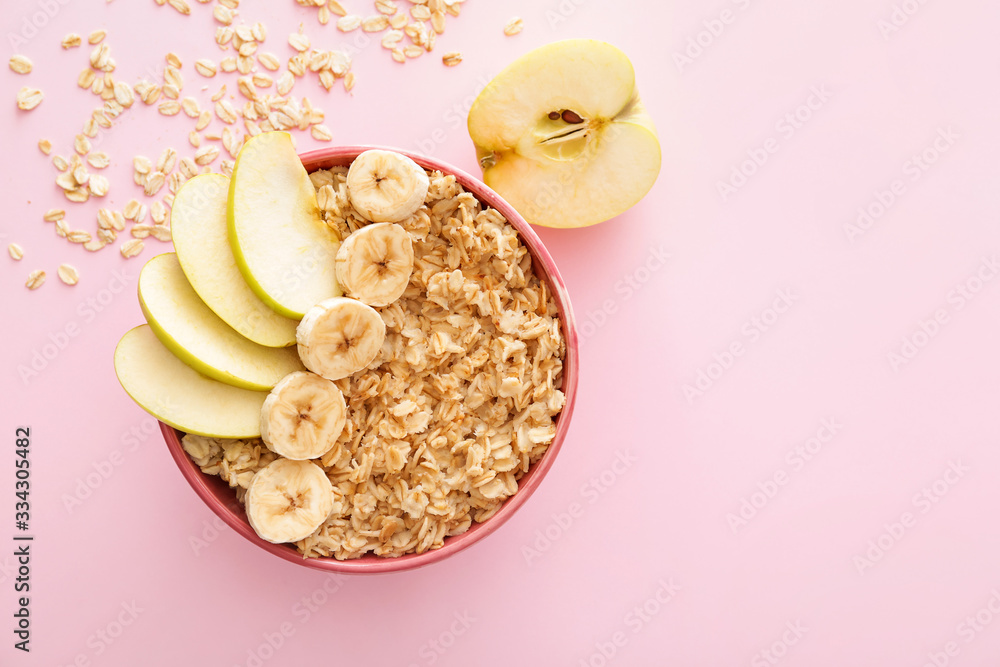 Bowl with tasty sweet oatmeal on color background