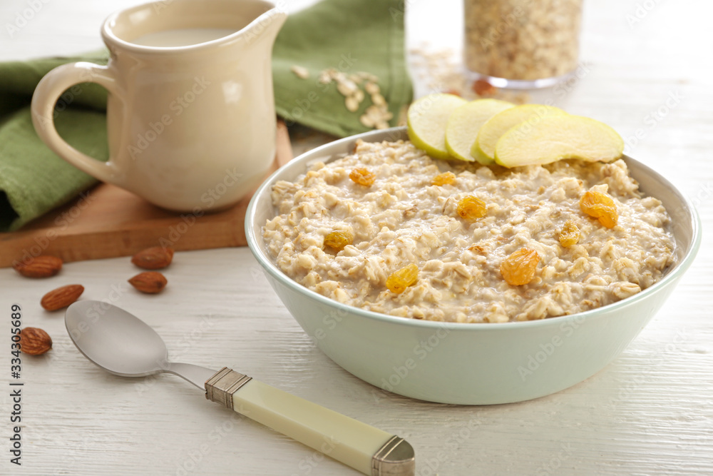 Bowl with tasty sweet oatmeal on table