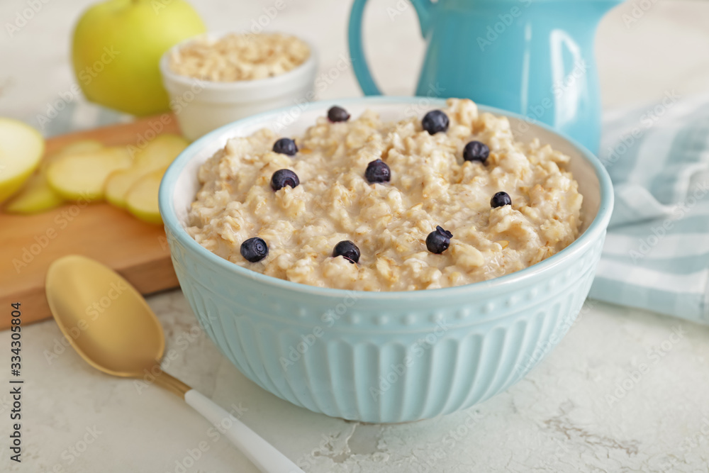 Bowl with tasty sweet oatmeal on table