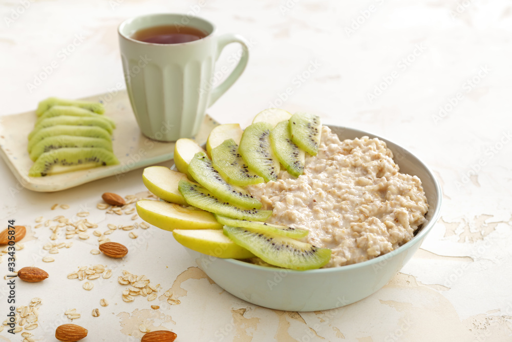 Bowl with tasty sweet oatmeal on table