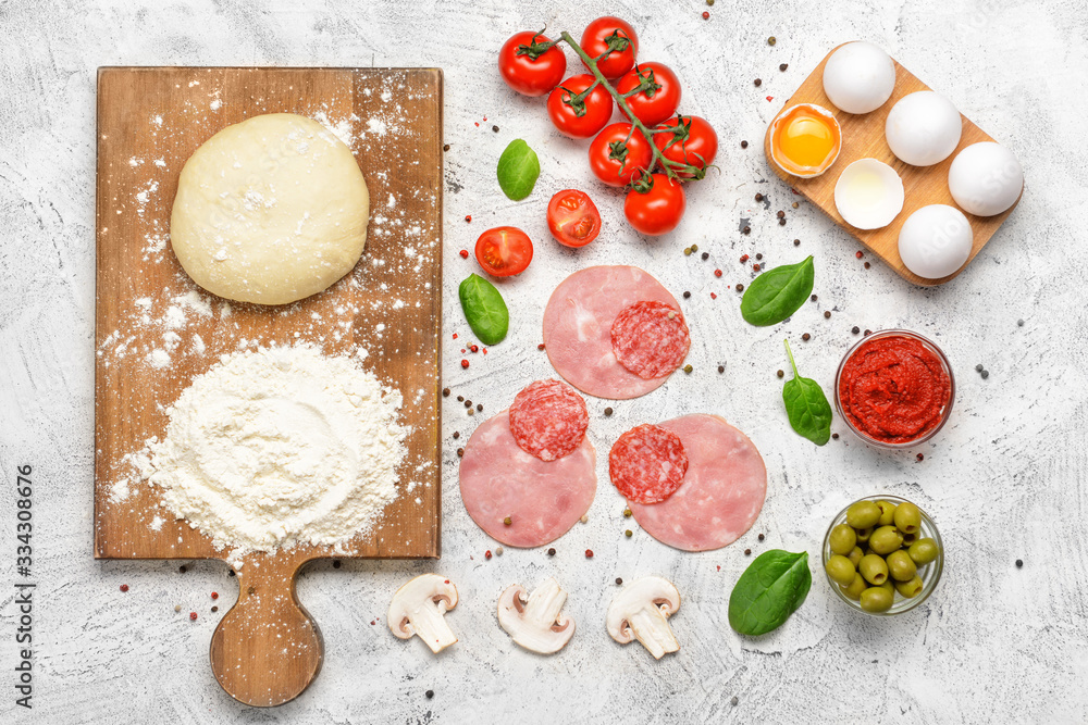 Ingredients for tasty pizza on light background