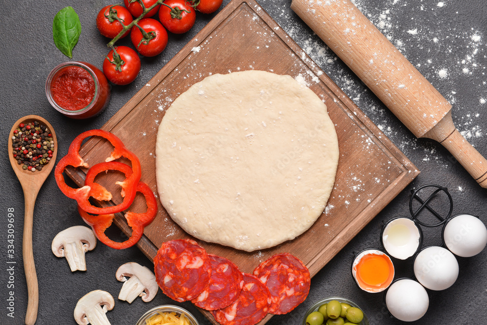 Ingredients for tasty pizza on dark background