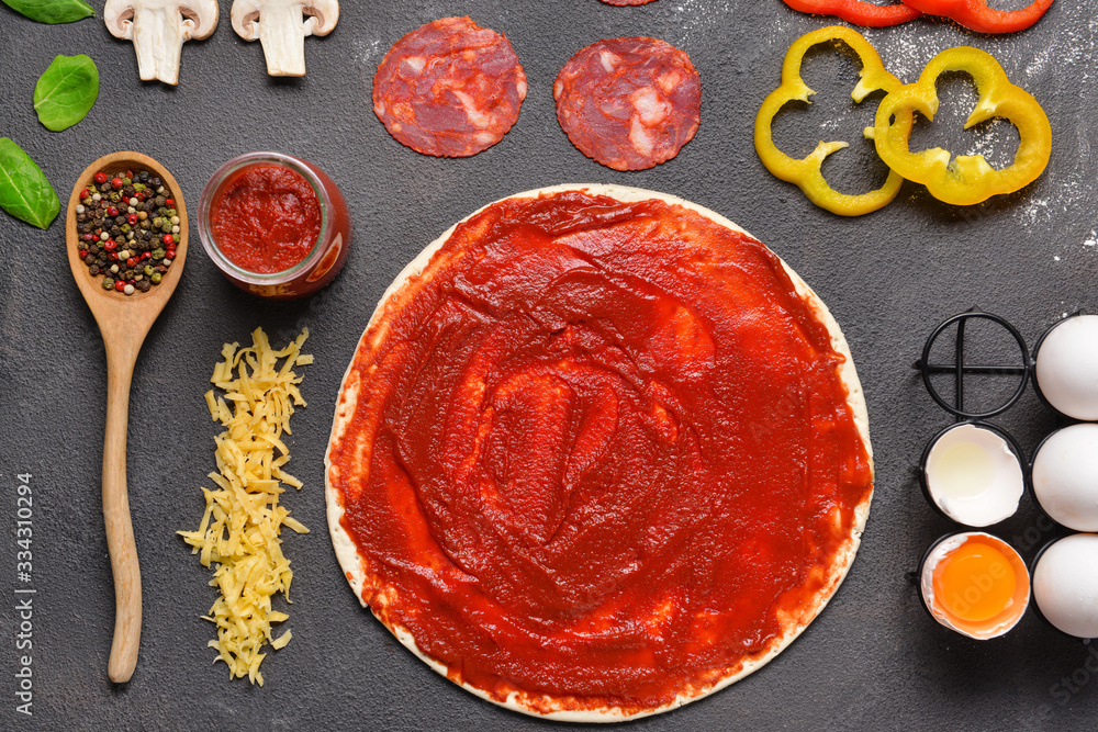 Ingredients for tasty pizza on dark background