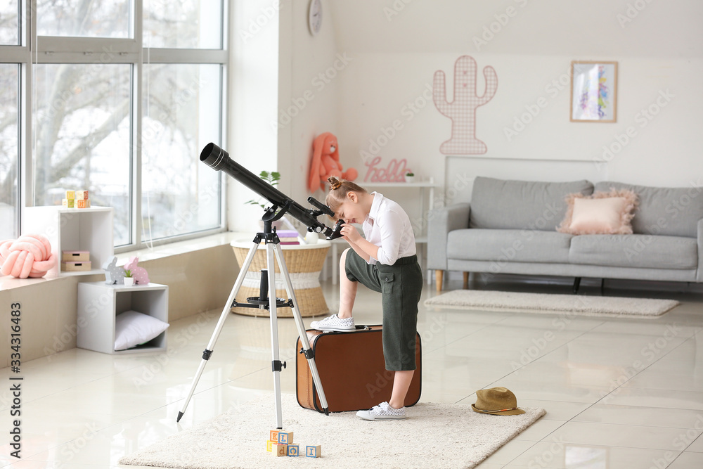 Cute little traveler with telescope at home