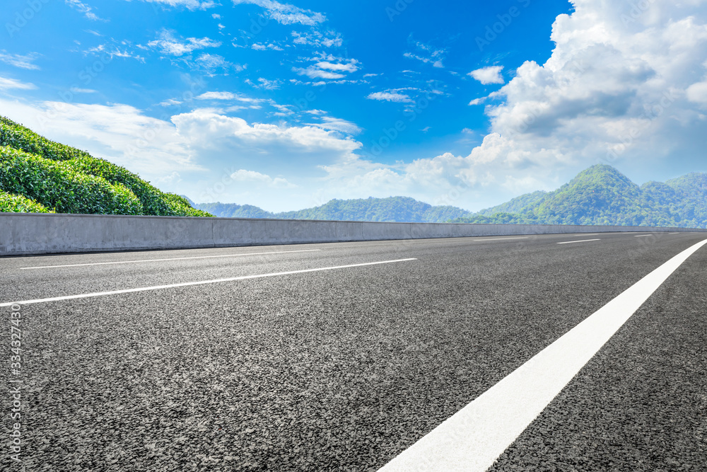 Empty asphalt road and green tea plantation nature landscape.