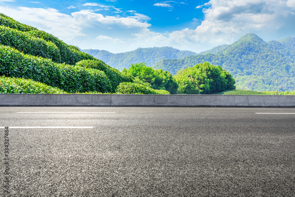 Empty asphalt road and green tea plantation nature landscape.