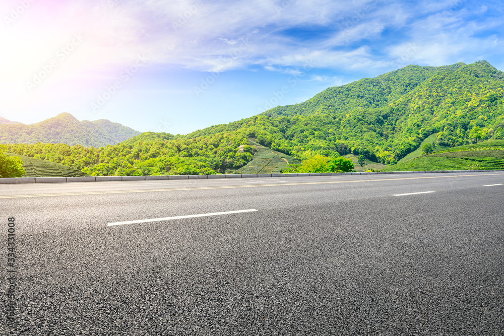 Empty asphalt road and green tea plantation nature landscape.