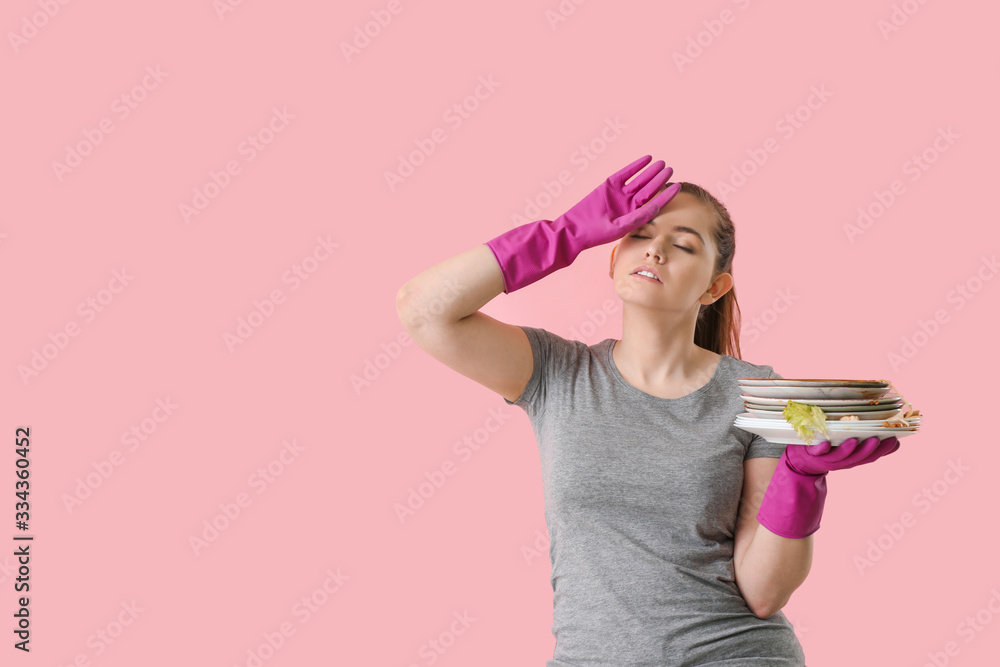 Tired woman with dirty dishes on color background