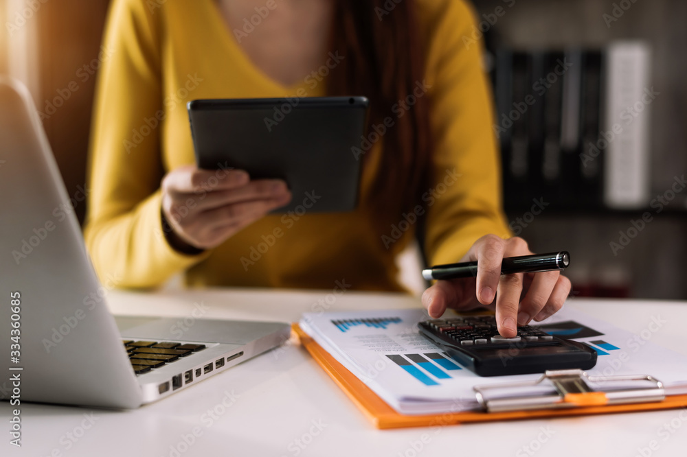 Businessman hands working with finances about cost and calculator and laptop with tablet, smartphone