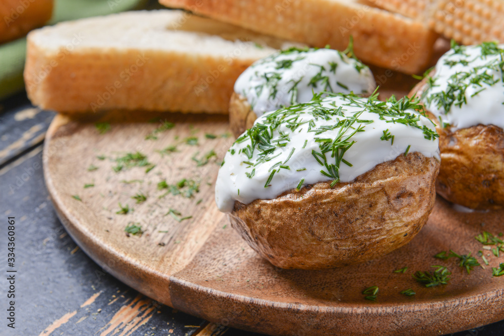 Tasty baked potato with sour cream on plate, closeup