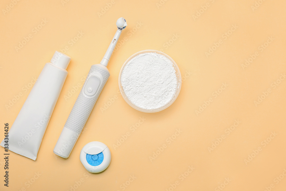 Tooth brush with paste and dental floss on color background