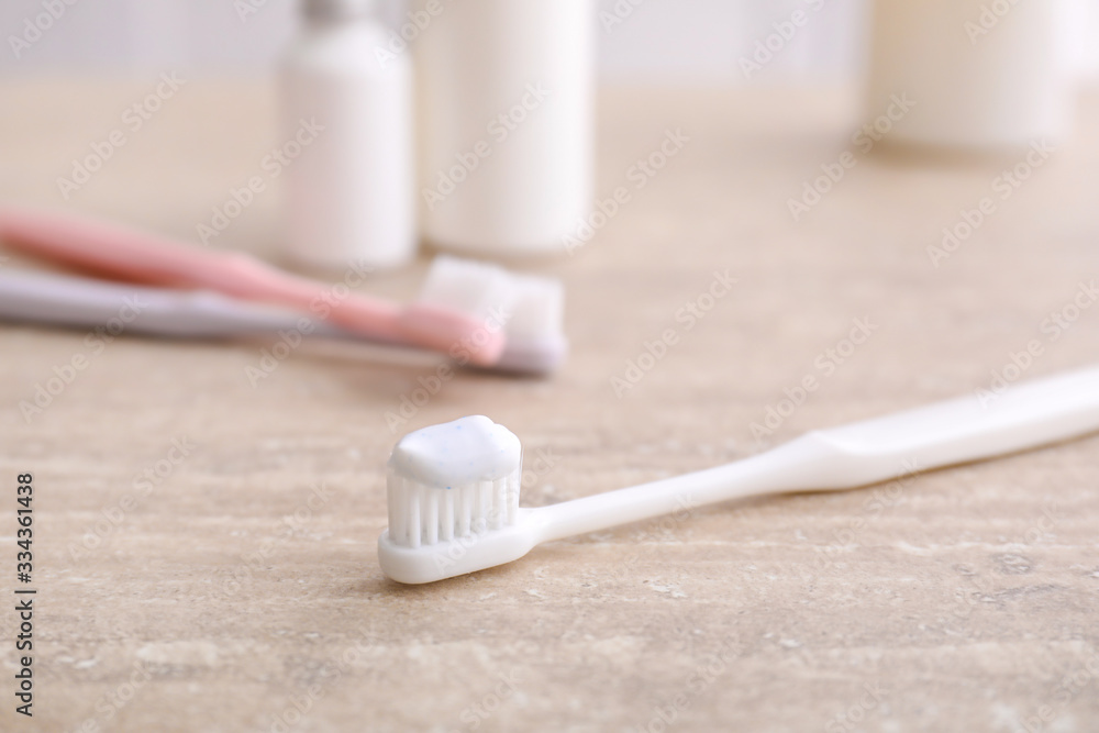 Tooth brush with paste on table in bathroom