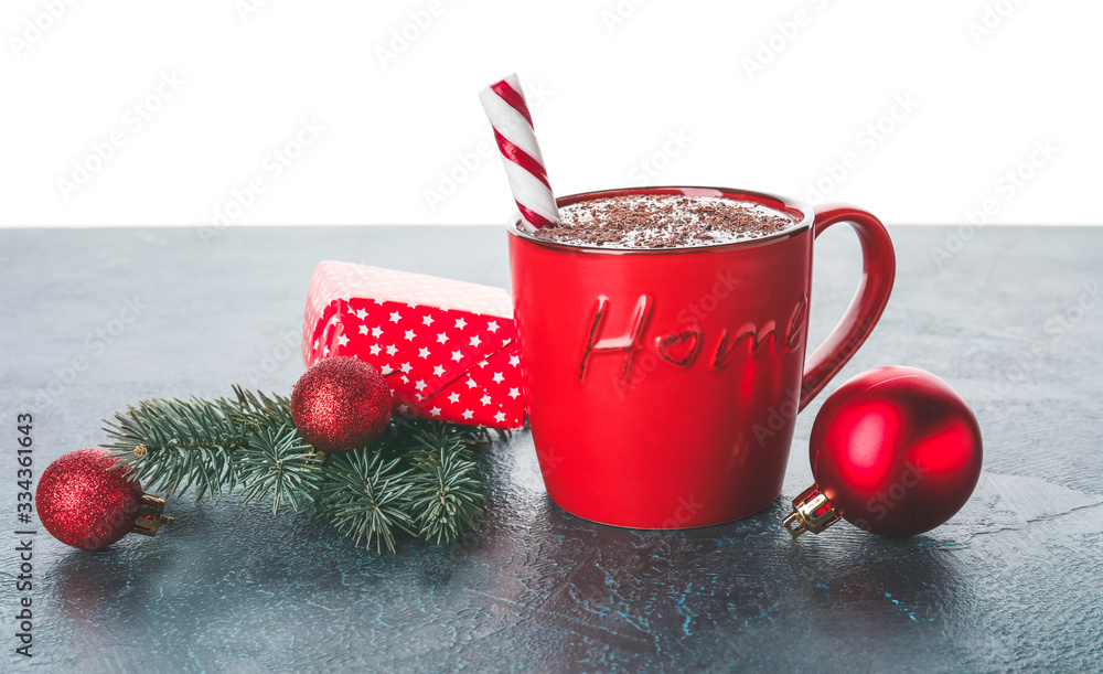 Cup of hot chocolate and Christmas decor on table against white background