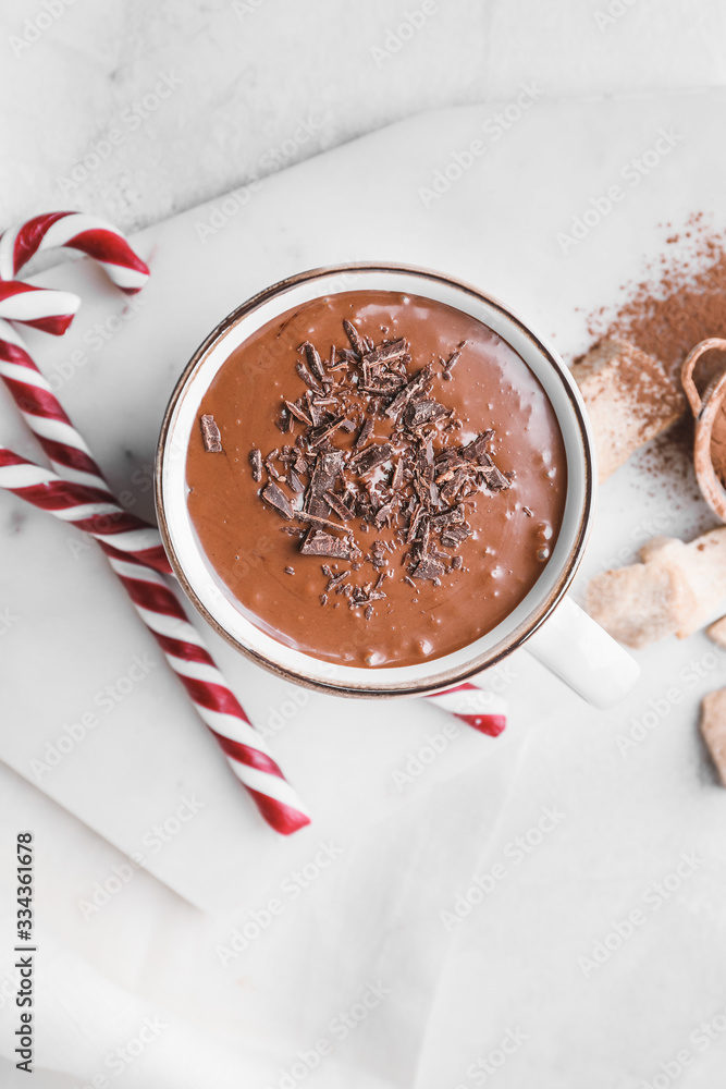 Cup of hot chocolate and candy canes on light table