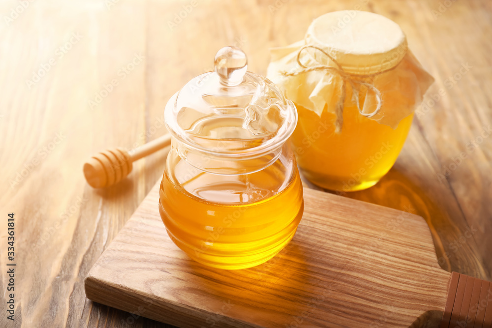 Jars of sweet honey on wooden background