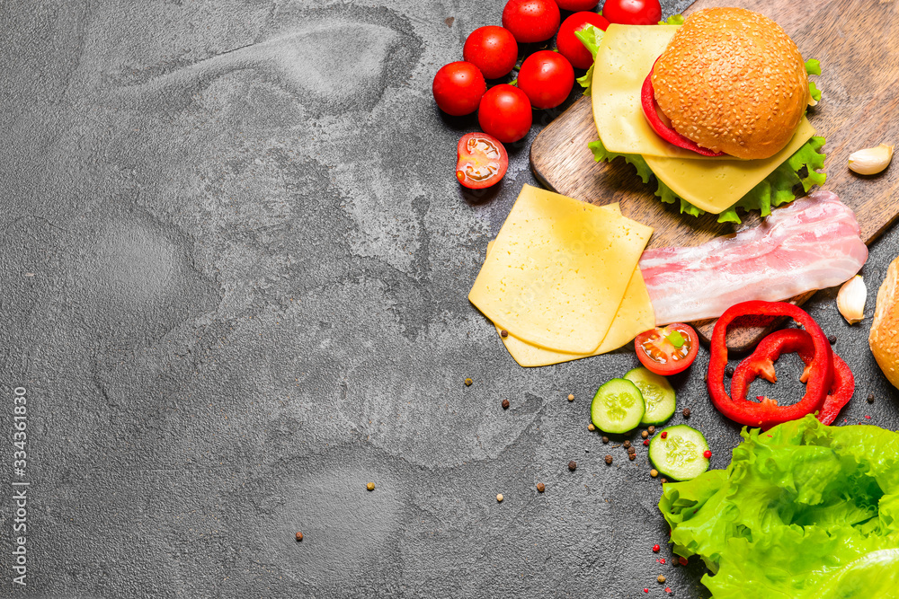 Ingredients for tasty burger on dark background