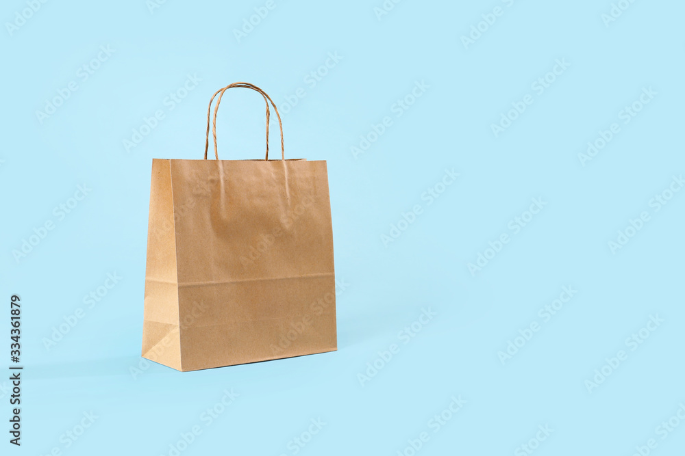 Paper shopping bag on color background