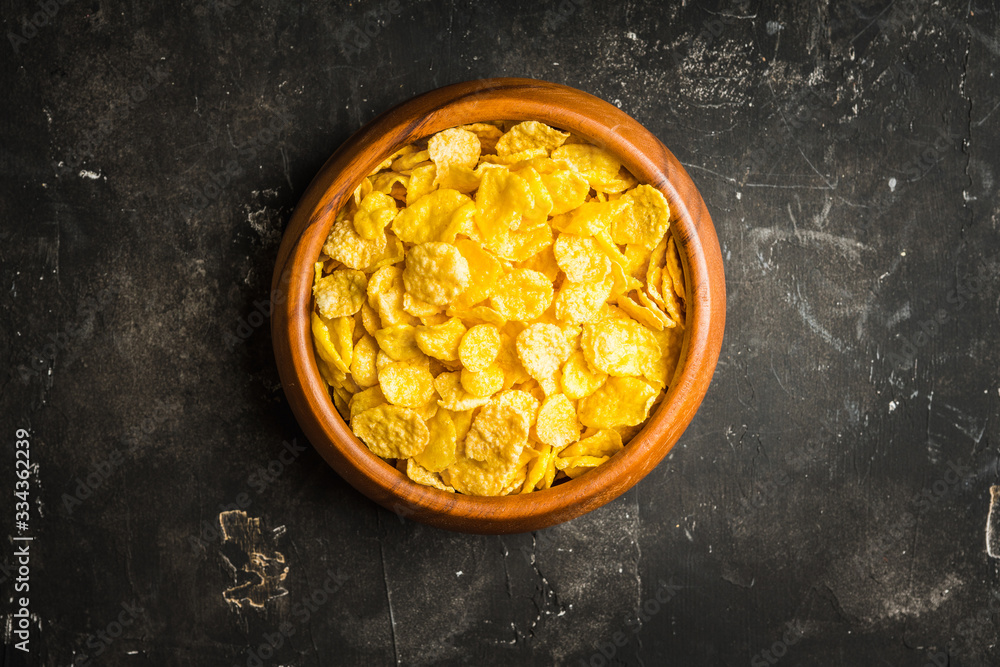 Tasty crispy corn flakes in bowl on the rustic background. Selective focus. Shallow depth of field.