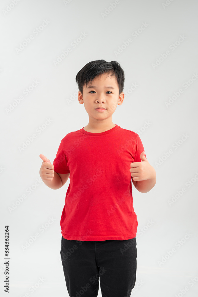 Portrait of beautiful little boy giving you thumbs up over white background