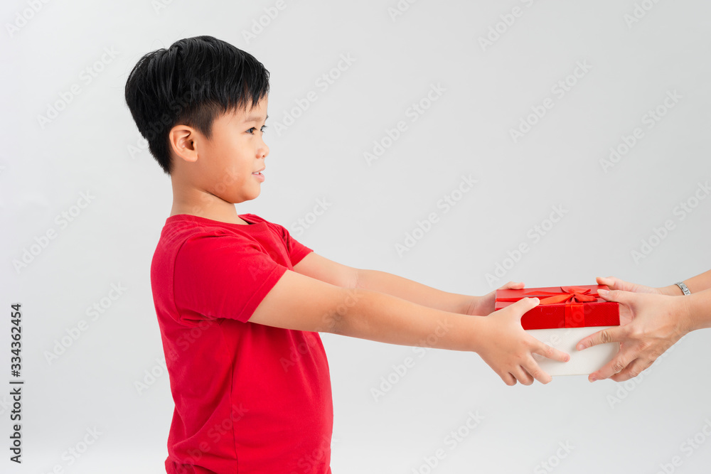 Take it! Side view of joy amazing cute little boy giving gift box to camera with excited smile and s