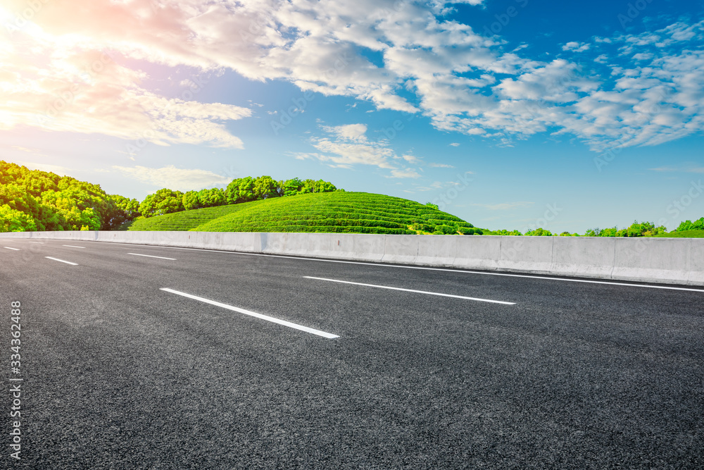 Empty asphalt road and green tea plantation nature landscape.