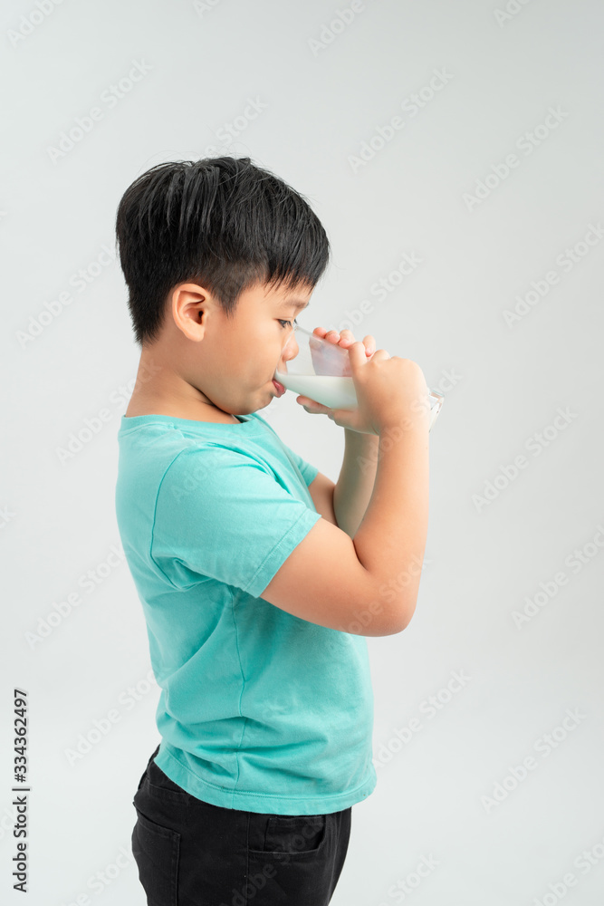 Adorable little boy with glass of milk on white background