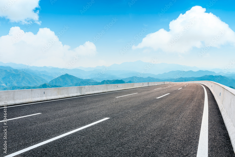 Empty asphalt road and mountain with sky on cloudy day.