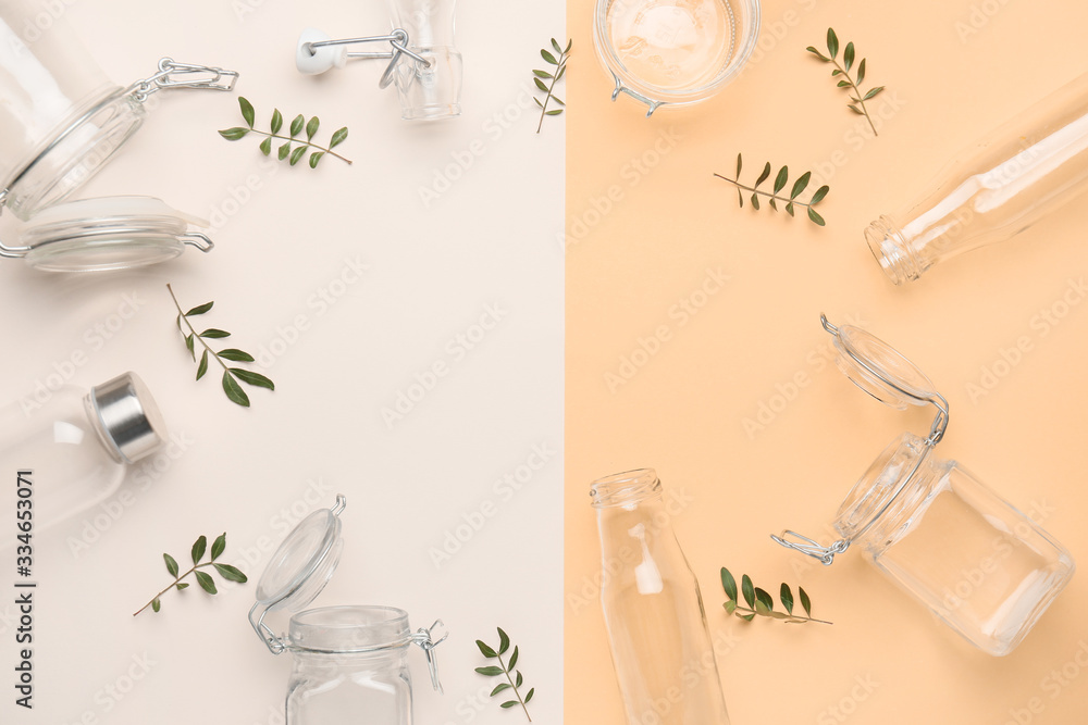 Frame made of glass eco bottles and jars on color background