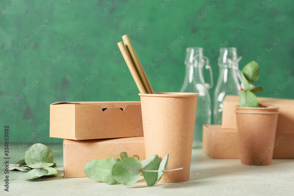 Eco containers for food and drinks on color background