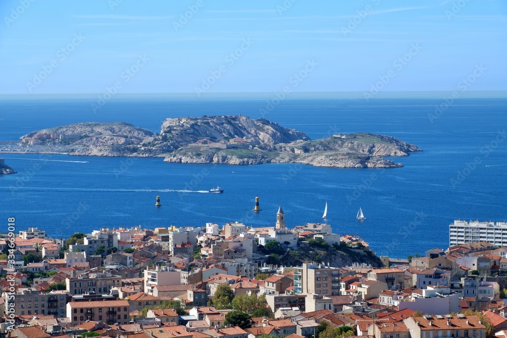 Aerial panoramic view of beautiful Marseille, France under blue sky; small island and city on the se