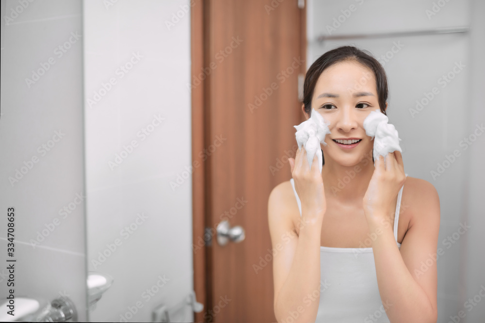 Woman clears a face skin foam on morning