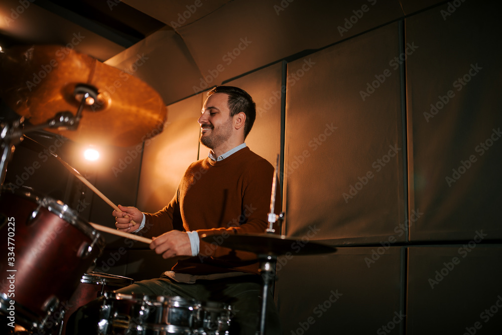 Man playing on drum set in the studio, copy space.