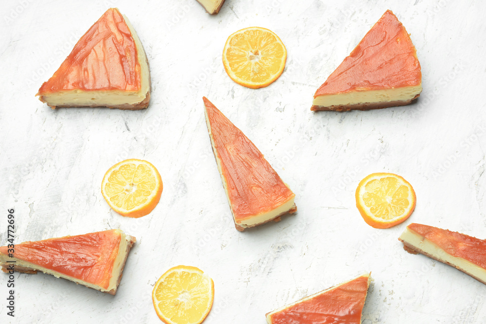 Slices of sweet caramel cheesecake with orange fruit on white background