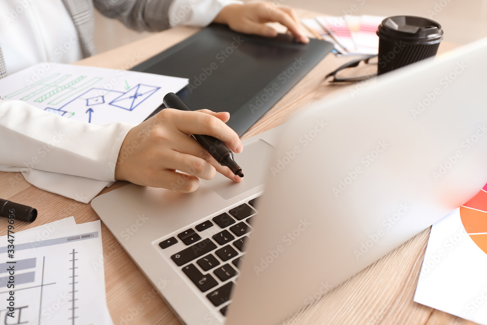 Young female designer working in office, closeup