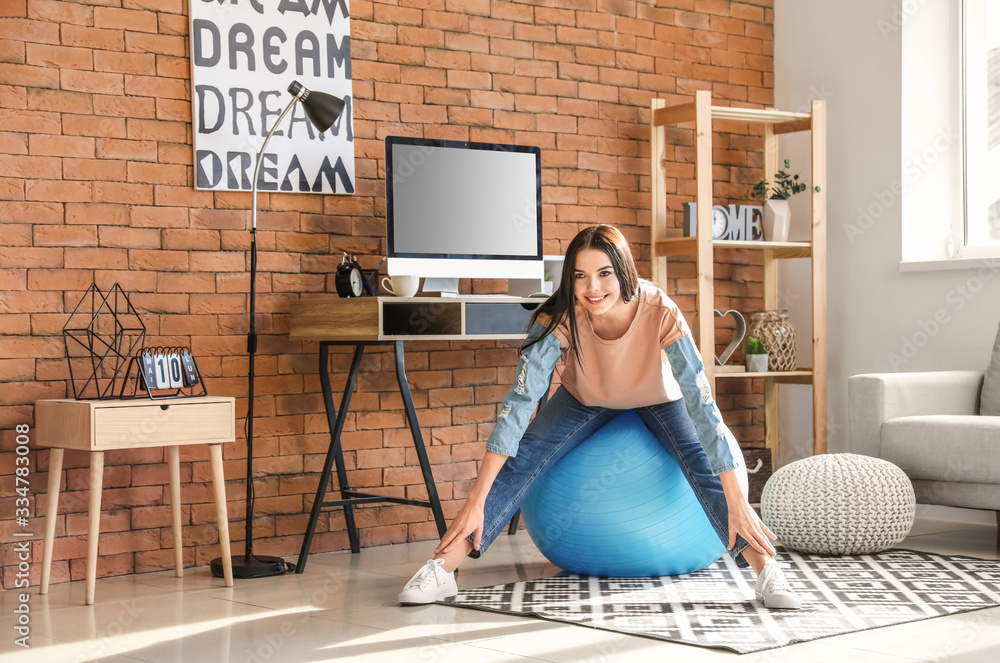 Woman doing exercises with fitness ball at home