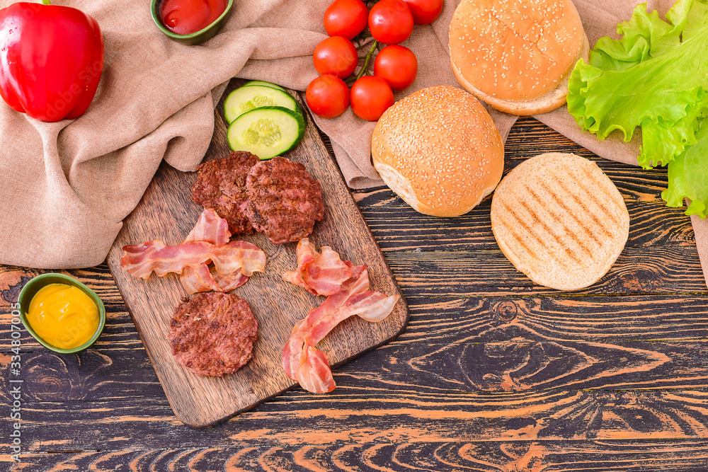 Ingredients for tasty burger on wooden table