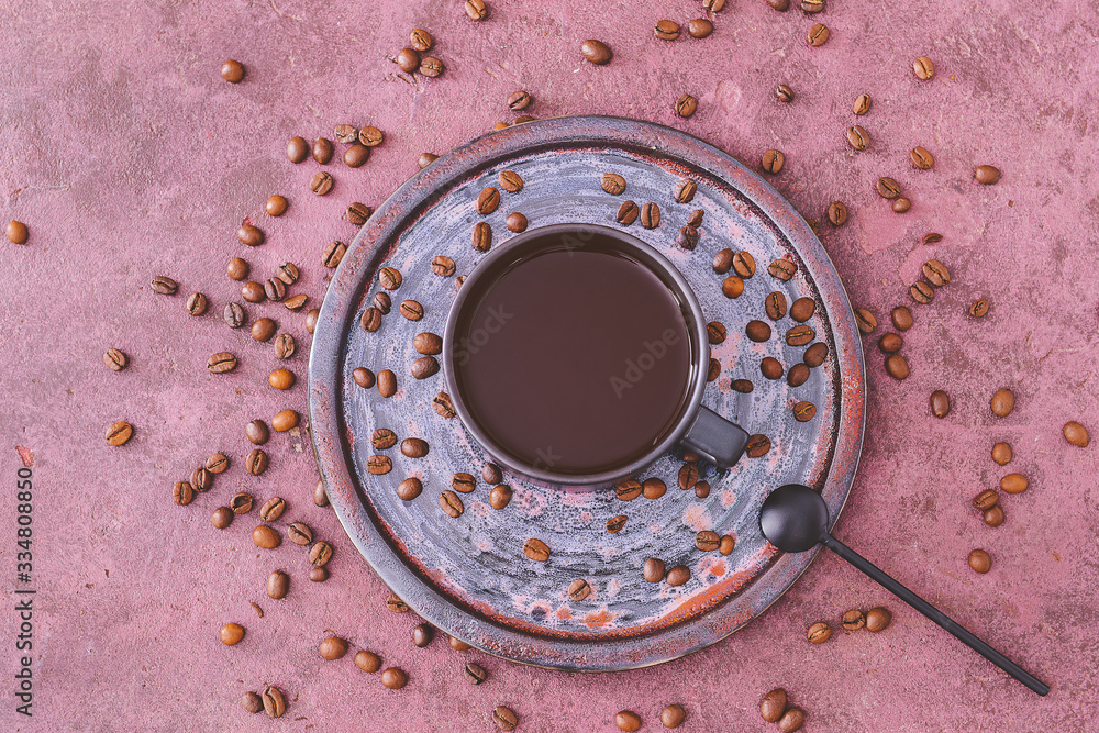 Cup of hot coffee and beans on table