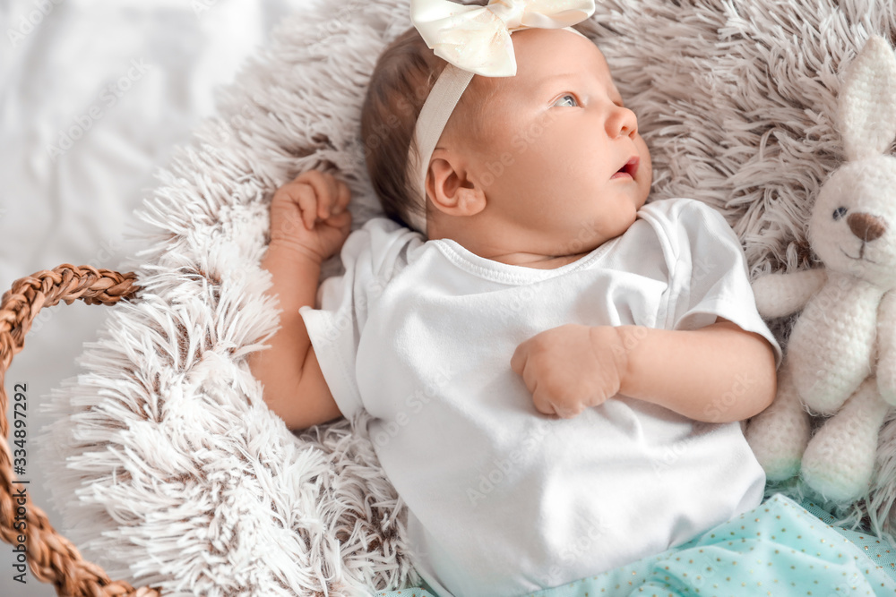 Cute little baby girl lying in basket